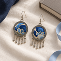 Both Azure Harmony embroidered fronts face upward on cream cloth beside navy fabric, a neutral-colored book and pale blue ribbon.