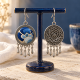 Azure Harmony embroidered front and floral reverse hanging from a dark blue T-bar stand, each with five short teardrop pendants.