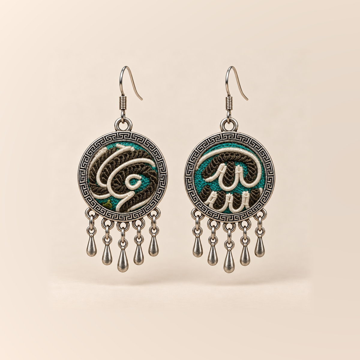 Teal Reverie Horsehair Embroidery earrings with cream raised curves over teal, black and olive stitching, patterned rims and five short teardrops.