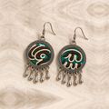 Both Teal Reverie embroidered fronts face upward on cream woven cloth, showing their distinct pale curving outlines and five short teardrops each.