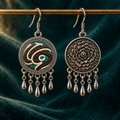 Teal Reverie embroidered front and floral reverse hanging from a gold-colored horizontal rod against dark teal cloth, with five short drops each.