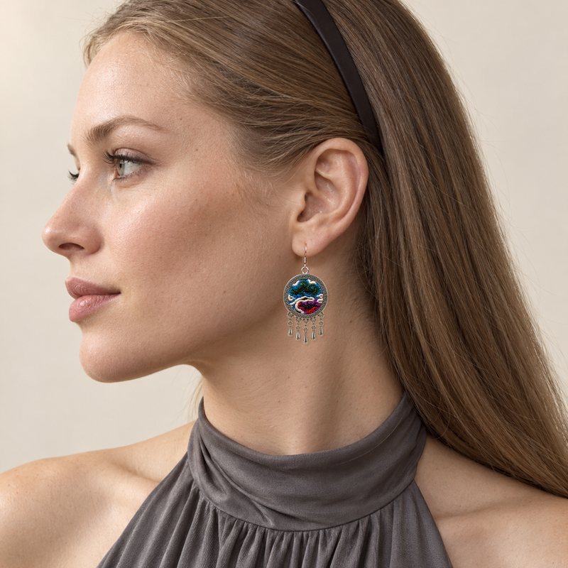 Chromatic Accord earring worn at the ear, showing blue, green, red and purple knotted textures, pale curves and five short teardrops.