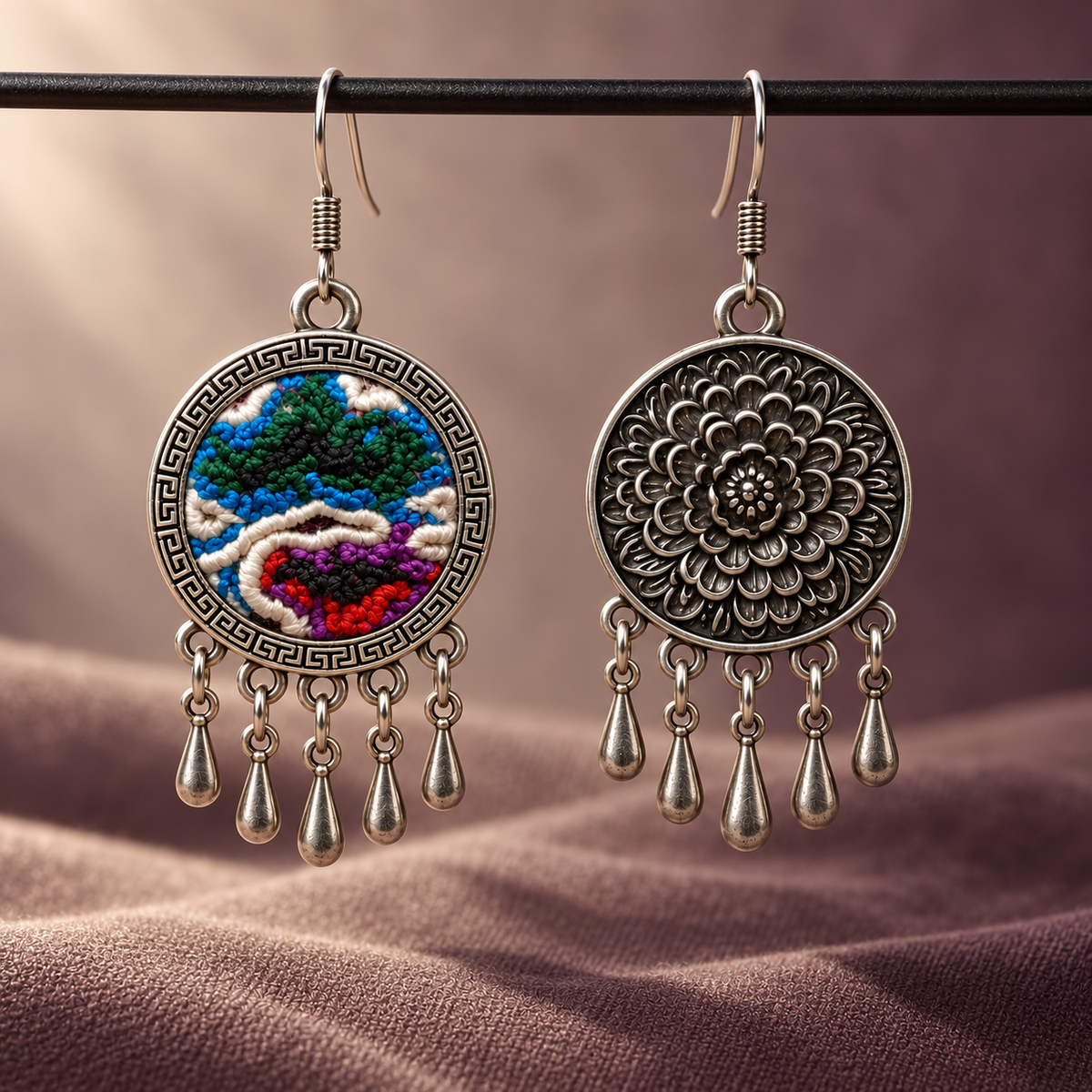 Chromatic Accord embroidered front and floral reverse hanging from a dark horizontal rod above dusty-mauve fabric, with five short drops each.